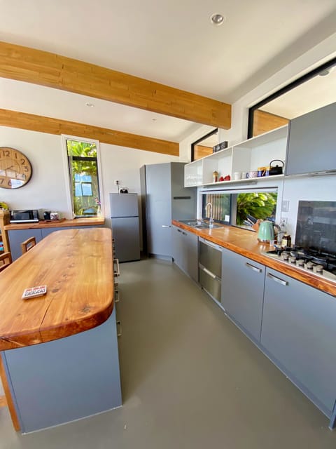 Functional and spacious kitchen has solid macrocarpa slab timber benches.