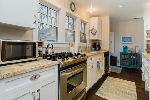 Cook at the stove while watching the kids play in the fenced backyard.