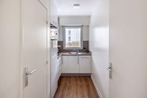 Well equipped kitchen with modern appliances, including a refrigerator, oven, and coffee machine, ideal for preparing your favorite meals.