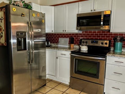Fullsize side-by-side refrigerator.  Electric Stove/oven with overhead microwave
