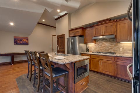 - Modern kitchen with granite counters
- Stainless steel appliances throughout
- Breakfast bar with stylish seating