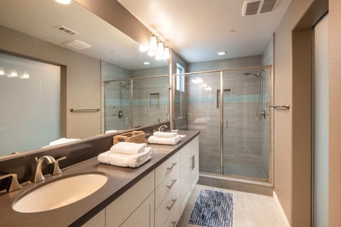 Dual sinks and ample counter space sit atop the bathroom vanity.  Indulge in some well-deserved self care in the spacious stand-up shower.