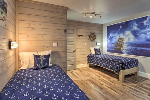 Bunk room features a nautical theme with shiplap walls, ship lights, and mural