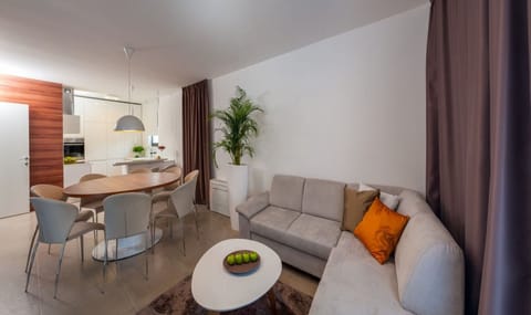 Living room with a sofa, dining area and a fully equipped kitchen on the ground floor of a Croatia luxury modern villa Trogir 1 with pool