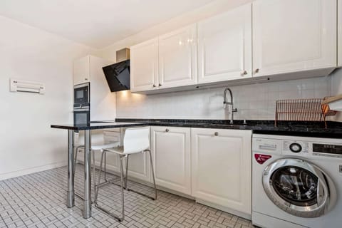Modern kitchen with sleek appliances, including a washer and dryer, perfect for long stays and home-cooked meals.