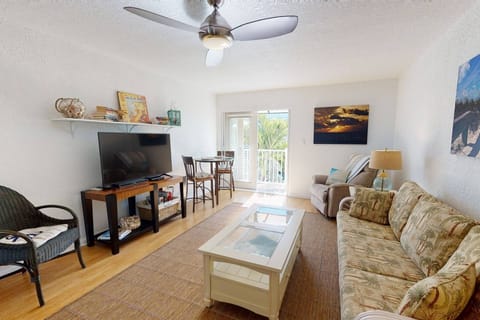 Clean and Comfortable Living Room Area with Big Screen TV and Balcony Access