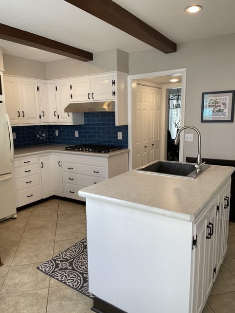 Sunny eat-in kitchen with new countertops, tile backsplash, and appliances