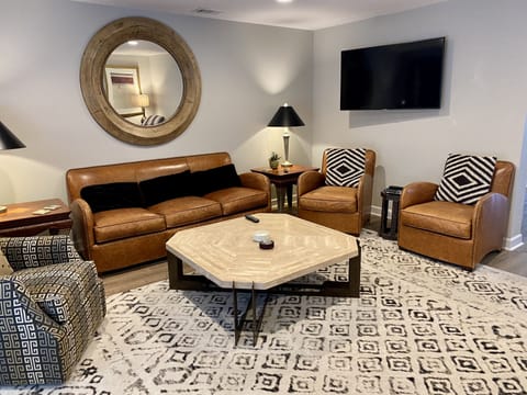 Gorgeous leather furniture, ample seating, two televisions, and a walk out patio