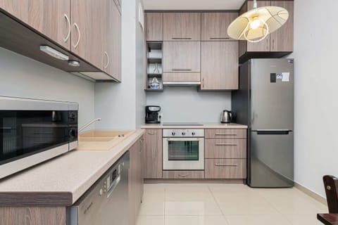 A compact kitchen with wooden cabinets and a small dining table, suitable for a cozy dining experience.