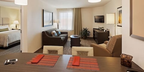 Lounge in a sunlit living room with TV and comfortable seating.