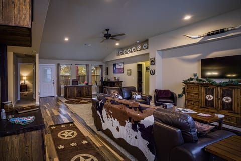 Fully finished living room with sofa, love seat, chairs and 50 inch smart TV. 