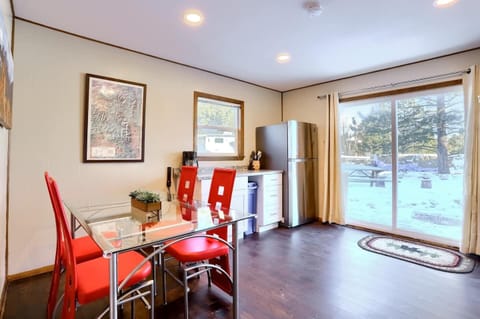 - Dine indoors with scenic outdoor views through glass doors that open to nature
- Clean modern lines meet rustic vibes with red chairs and wood style flooring
- Enjoy meals or morning coffee while soaking in the peaceful snowy backdrop