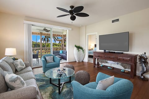 Bright and breezy living area with modern Hawaiian décor, plush seating, and flat-screen smart TV — the perfect spot to unwind after a day on the golf course.