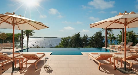 Private terrace of Croatia luxury villa for rent with heated pool surrounded by deckchairs and sundeck
