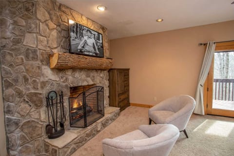 Cozy Stone Gas Log Fireplace with Comfy Chairs in Master Bedroom