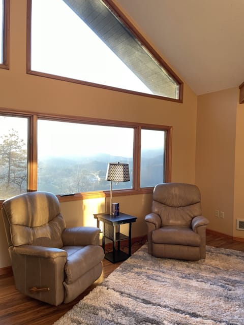 Master bedroom with reclining chairs and reading/phone charging table.