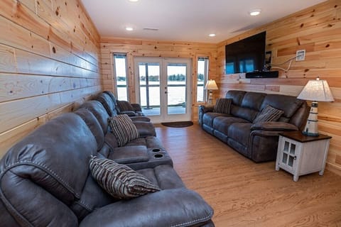 Walk-out level TV Room seats 7 w/ pwr recliners, 55" 4K TV, views of Stone Lake.