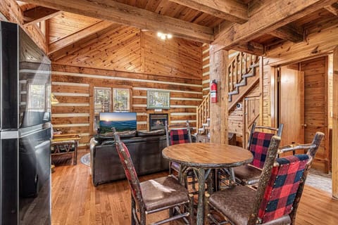 Kitchen and dining open to the living room area. Bathroom door on the right and steps to the loft bedroom.