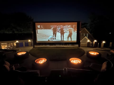 Large outdoor movie experience with surround sound and gas fire pits.