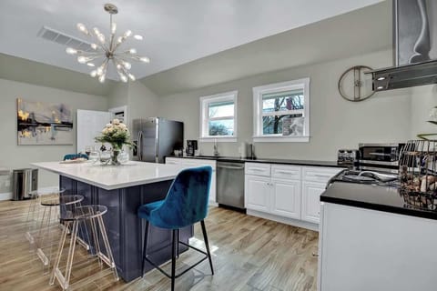 The kitchen provides ample countertop space and showcases modern conveniences, including a fridge with an ice maker, electric stove, and dishwasher, enhancing culinary efficiency.