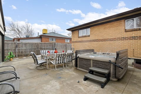 A luxurious Jacuzzi paired with an outdoor table under a bright sky, creating the perfect setting for relaxation and enjoyment in the open air.