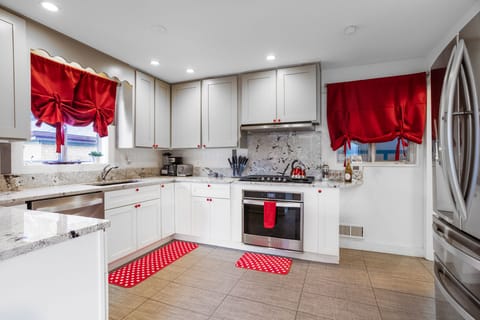 A kitchen designed with striking red and white contrasts, offering a sleek and stylish space for culinary creativity.