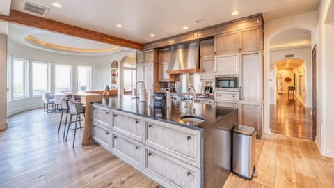 Gorgeous farmhouse style kitchen w/ large island, paneled fridge, & large range
