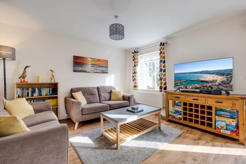 Large settees in the open plan living area with 50" smart tv and games console