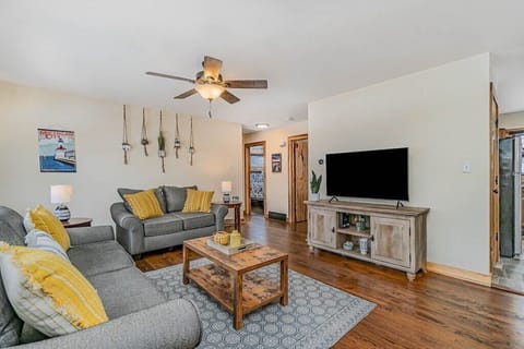 Living area with comfortable couches, fresh decor, and a smart TV.