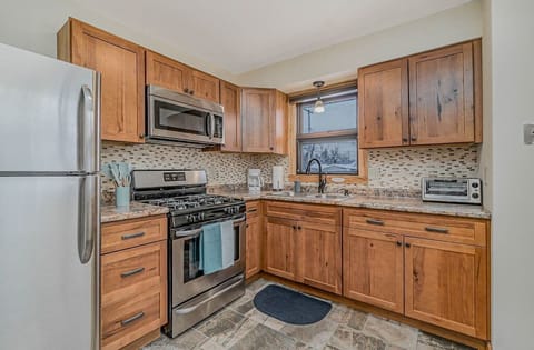 Fully stocked kitchen with stainless steel fridge, microwave, and oven/stove.