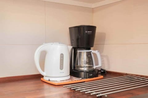 Small coffee setup with a kettle and cups on a tray, ideal for morning refreshments.