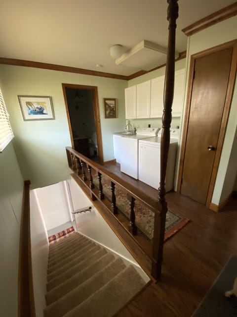 Laundry room with bathroom. Stairs to basement with handrail.