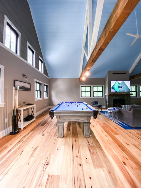 Play pool in the large open living room that overlooks mountain peak views.