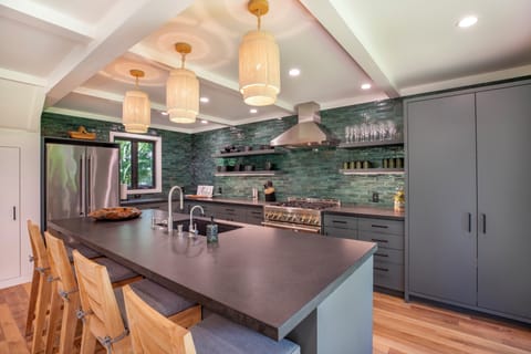 Fully equipped modern kitchen with a central island and hanging lights.