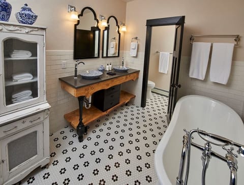 The master bathroom has a heated floor. The same family tree that was used to build the dining room table was used to build the vanity. There is a shower across from the toilet.