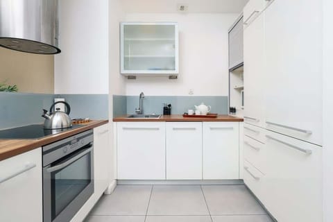 A kitchen view from the living area, featuring stainless steel appliances and a clean, open design.
