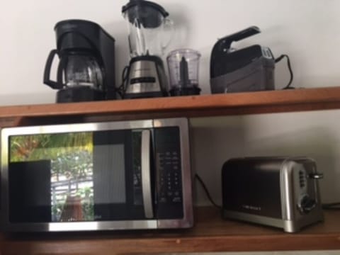 An array of small appliances, dishes, utensils make for a well-stocked kitchen.