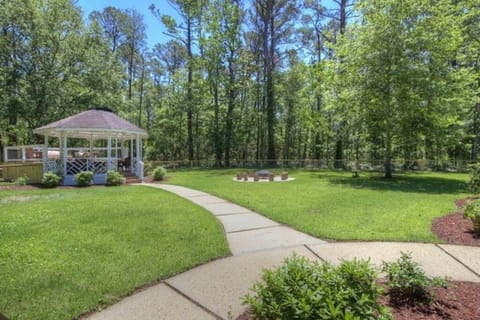 Spacious fenced in backyard with firepit, gazebo, and outdoor games