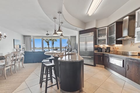 This gourmet kitchen, featuring stainless steel appliances and granite countertops, seamlessly flows into the spacious living area, perfect for entertaining and enjoying breathtaking views.