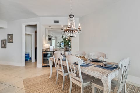 Gather around the beautifully appointed dining table, where every detail, from the textured placemats to the delicate glassware and serene colored plates, creates an inviting atmosphere for memorable meals.