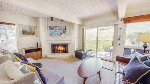 Living space featuring a gas fireplace and walk-out patio facing the ski hill