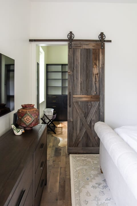 A classic barn door leads to the main bedroom’s closet.