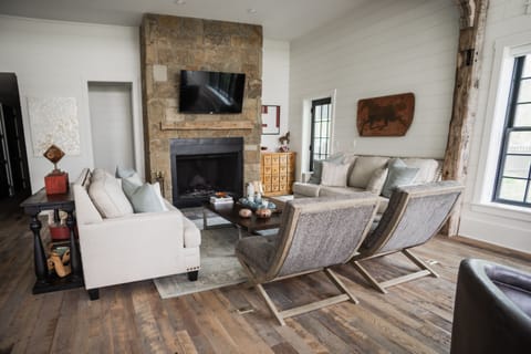 A classic stone fireplace is the centerpiece of the beautifully lit living room.