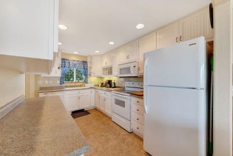 The kitchen is well stocked with utensils, dishes and cookware.