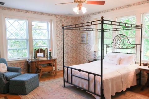 Reynolda room with queen bed, armoire, vanity and comfortable chairs for lounging.
