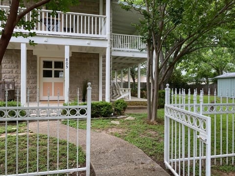 White custom iron fencing with gates line the front of the property.