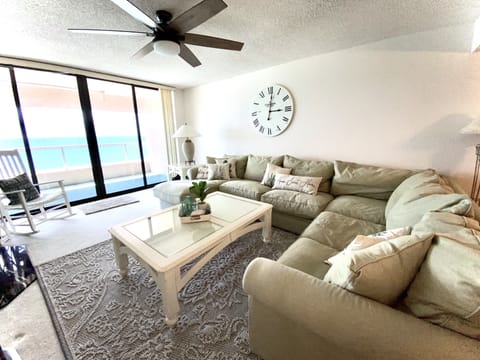 Family room with cozy couch and large Gulf view balcony 