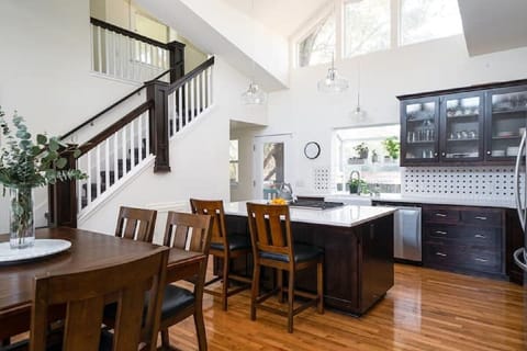 Well stocked, sunny kitchen with pub table and kitchen bar seating