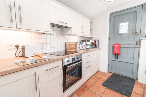 Salty's Cottage, St Agnes. Ground floor: Kitchen with a four-ring induction hob, electric oven, microwave, fridge and dishwasher
