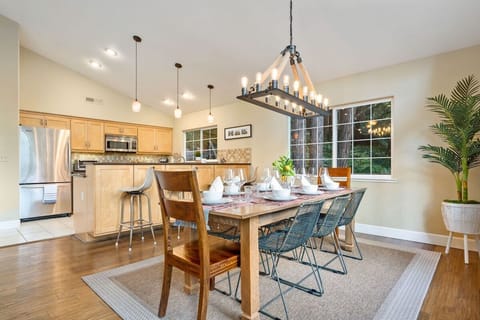 An exquisite chandelier with Edison filament bulbs lights an inviting dinner table ready for your shared meals.
